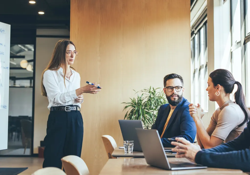 A strategist presenting to the team in a sunlit meeting room